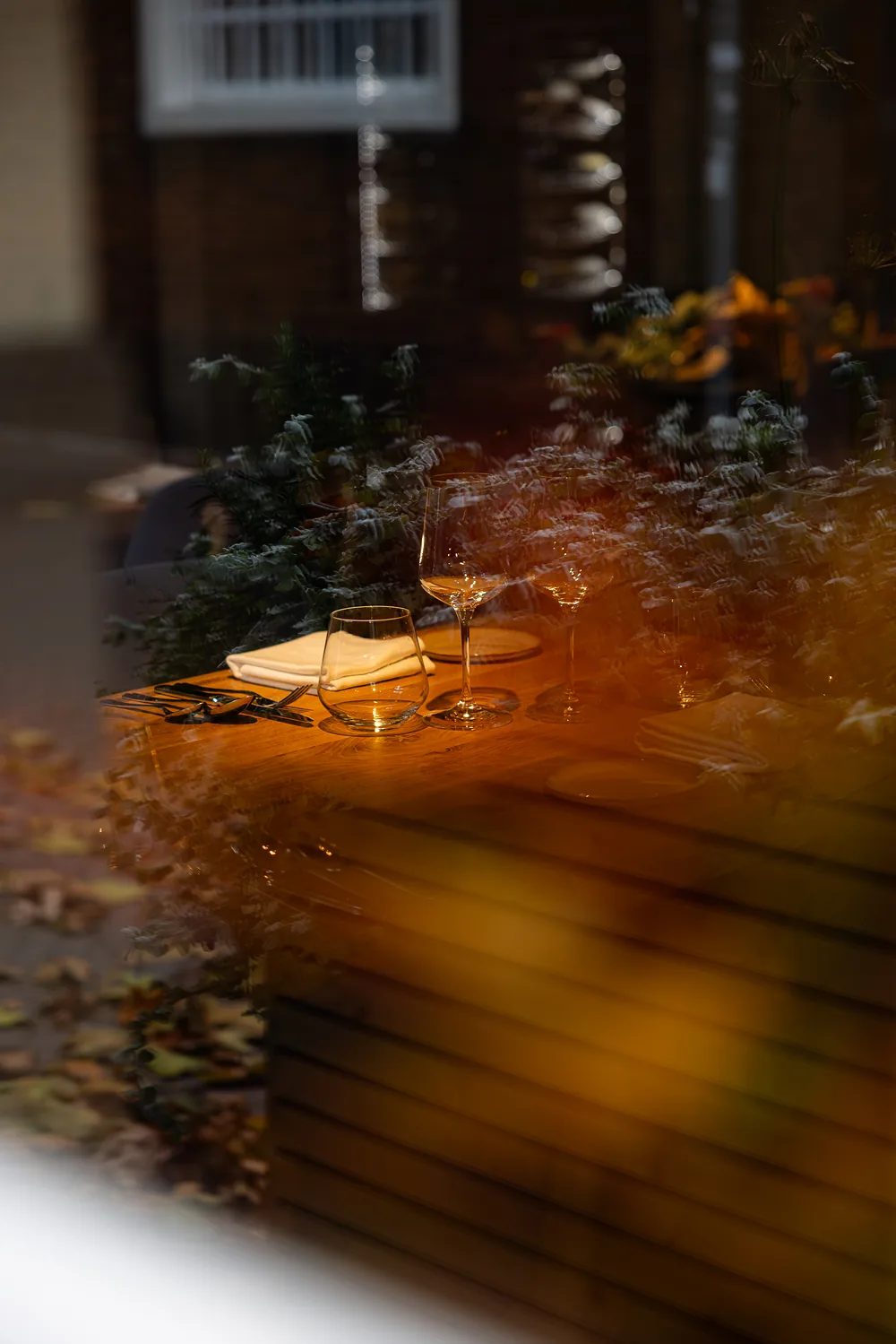 Gedekte tafels achter het raam, 's avonds