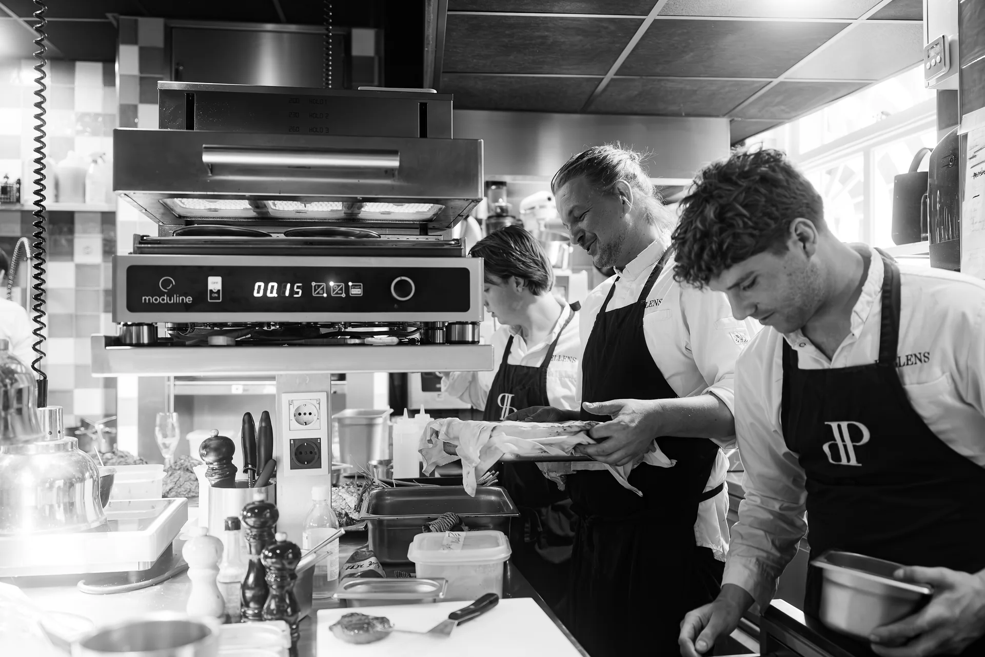 Zwart-witfoto van de koks aan het werk in de keuken van Pellens
